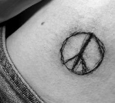 a woman's stomach with a peace sign tattoo on it