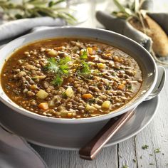 a white bowl filled with soup on top of a wooden table