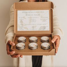 a woman is holding a box with candles in it and the contents inside are labeled