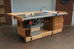 a table sawing machine sitting in front of a garage door