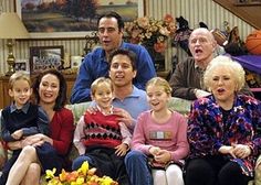 a group of people sitting on top of a couch in front of a coffee table