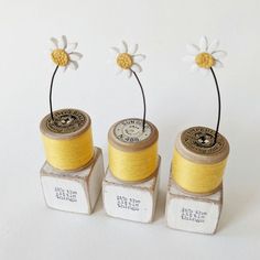 two spools of yellow thread with flowers on them sitting next to each other