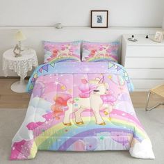 a bed with a pink unicorn comforter and matching pillow cases on top of it