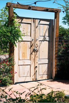 an old wooden door in the middle of a garden