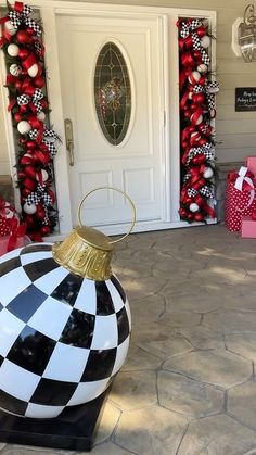 a black and white checkered ornament in front of a house with christmas decorations