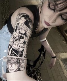 a woman with a black and white tattoo on her arm is looking down at the ground