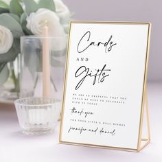 a wedding card and gifts sign next to a vase with white flowers in the background