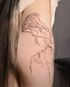 a woman's thigh with a jellyfish tattoo on her left side ribcage