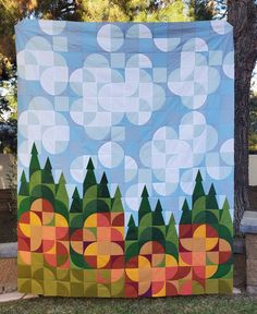 a large quilt hanging on the side of a tree