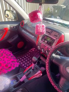 the interior of a car decorated with pink and red decorations