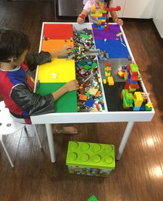 two children playing with legos on a table