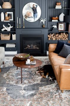 a living room filled with furniture and a fire place in front of a wall mounted fireplace