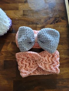 two crocheted bow ties on top of a wooden table