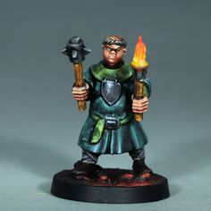 a small figurine with two torches in his hands