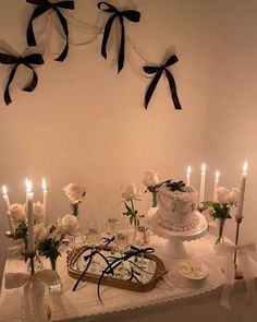 a white table topped with a cake and lots of candles