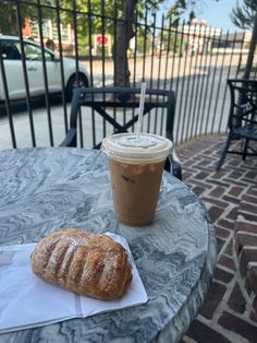 a pastry and coffee on a table outside