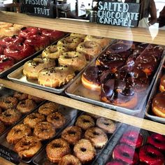 a display case filled with lots of different types of doughnuts and pastries