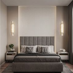 a large bed sitting in the middle of a bedroom next to a wall mounted lamp