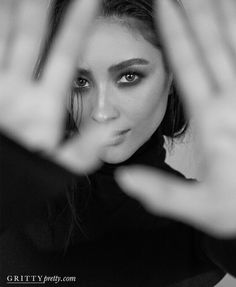 a black and white photo of a woman with her hands in the air