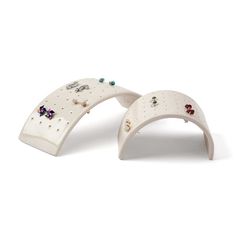 two white ceramic rings with different colored stones on each one and an earring holder in the middle