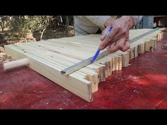 a person is using a blue pen to cut wood