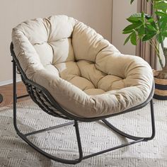 a chair that is sitting in the middle of a room with a potted plant