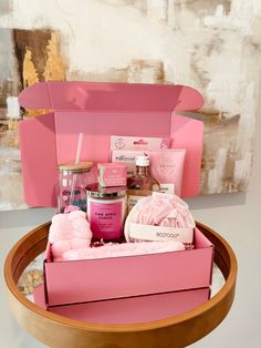 a pink box filled with lots of items on top of a table