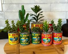 four tins with plants in them sitting on a table