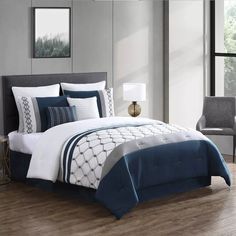 a bed with blue and white comforters in a room