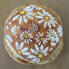 a pancake with white and yellow flowers on it sitting on top of a wooden table