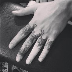 two hands with tattoos on their fingers