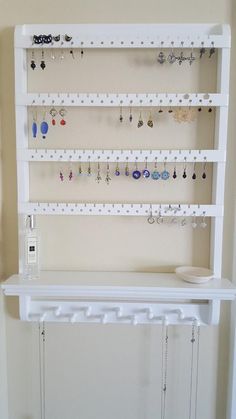 there is a white shelf with earrings on it