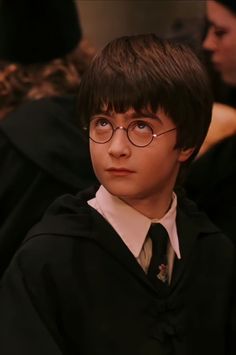 a young boy wearing glasses and a harry potter robe