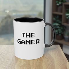 a black and white coffee mug sitting on top of a wooden table