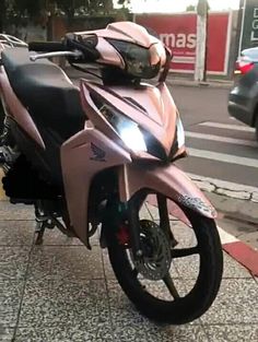 a pink motorcycle is parked on the sidewalk