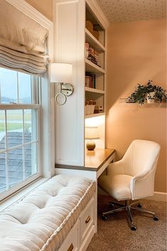 a white chair sitting next to a window near a desk with a lamp on it