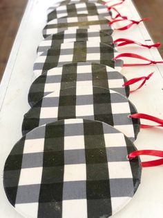 black and white checkered paper plates lined up on a table with red ribbon around them