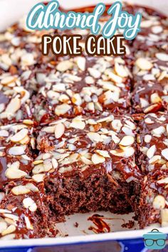 a chocolate cake with almonds on top in a blue and white baking dish that is cut into squares