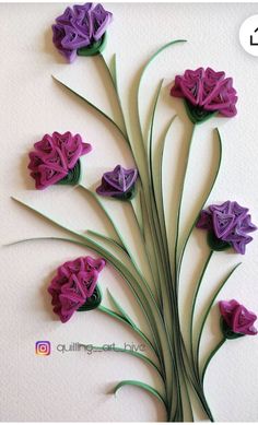 purple flowers are arranged in the shape of leaves on a white wall with green stems