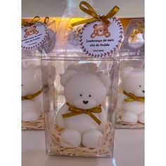 three small white teddy bears in clear boxes