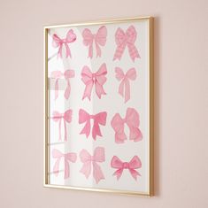 a pink wall with a gold frame and some bows on it