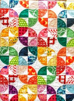 a colorful quilt with many different colored circles on the front and back, all in various colors