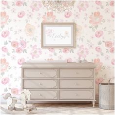 a baby's nursery room with floral wallpaper and pink flowers on the walls