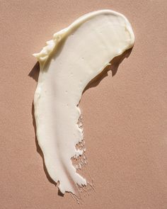 a half eaten piece of white cake sitting on top of a pink tablecloth covered in icing