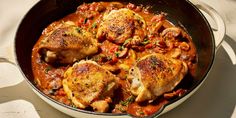 a pan filled with chicken and vegetables on top of a table