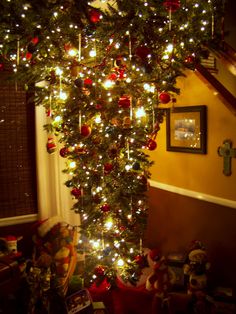 the christmas tree is decorated with red and gold ornaments