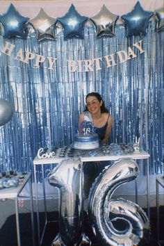 a woman sitting in front of a birthday cake