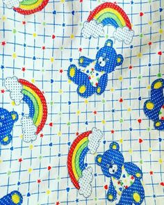 the fabric is very colorful and has teddy bears on it, with rainbows in the background