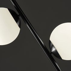 two black and white lamps on a dark background