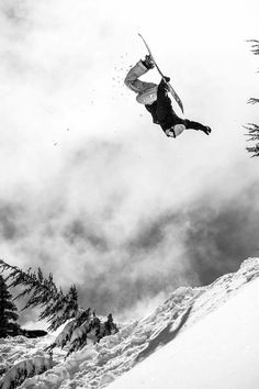 a man flying through the air while riding skis on top of snow covered ground